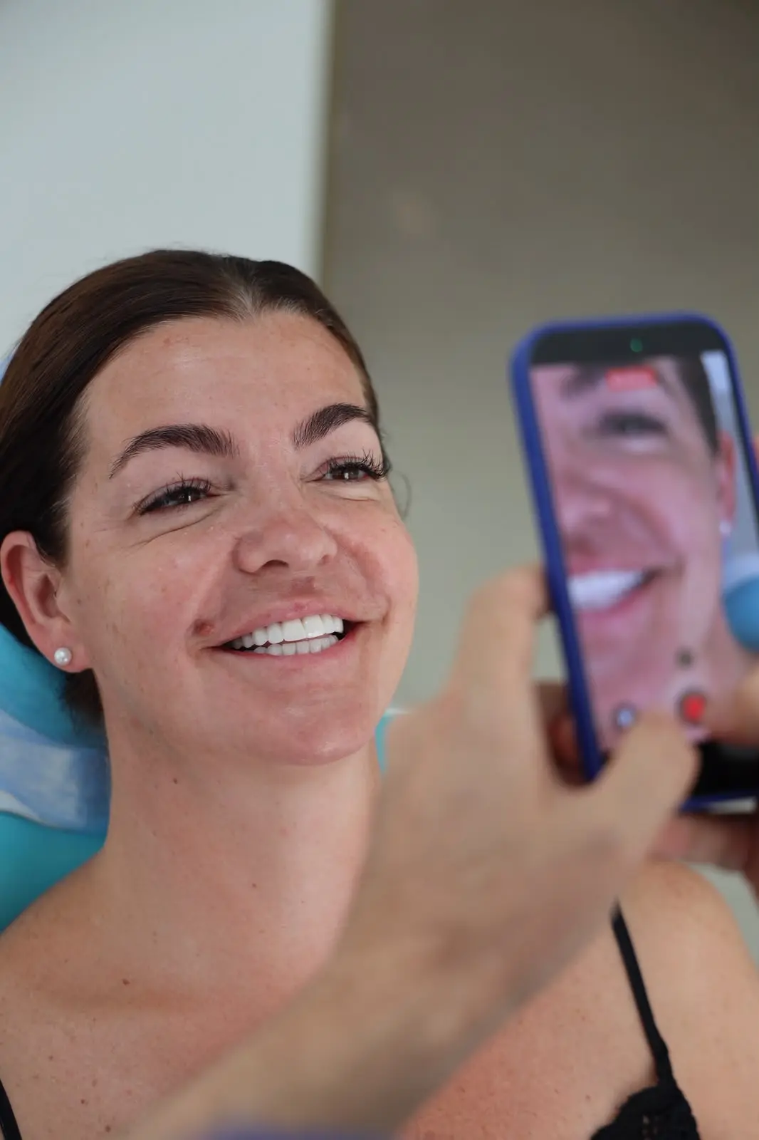 H.S. Dental patient smiling while her result is photographed